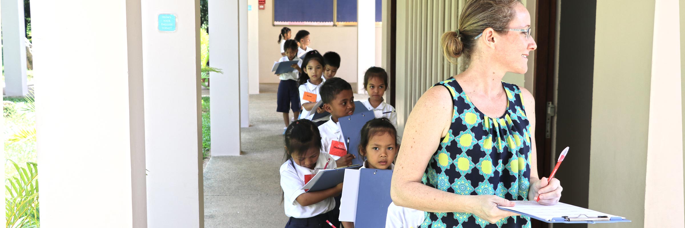 JPA teacher leading Grade 1 students around campus.  Jay Pritzker Academy, Siem Reap, Cambodia. Jay-Pritzker-Academy-Siem-Reap-Cambodia